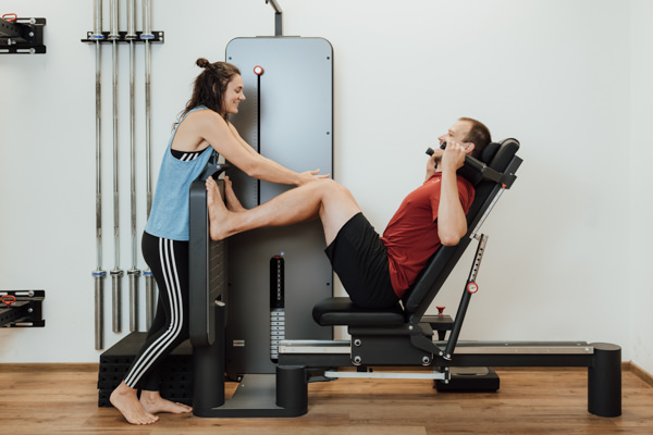 Michelle von corpus et animus korrigiert Kunden beim Training an der Beinpresse